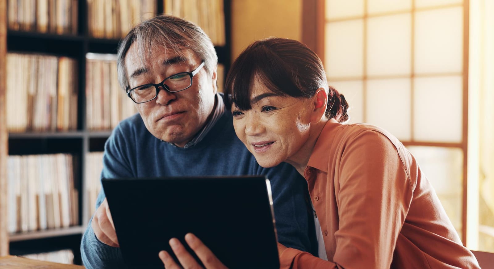 タブレットを一緒に見る高齢の夫婦の様子